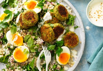 Baked falafel on plate with salad, fresh herbs and eggs